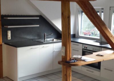 Wohnküche - klein aber fein - : Offene Küche im Wohnbereich in Weiß Glänzend. Arbeitsfläche in Schwarz mit passender Nischenrückwand.